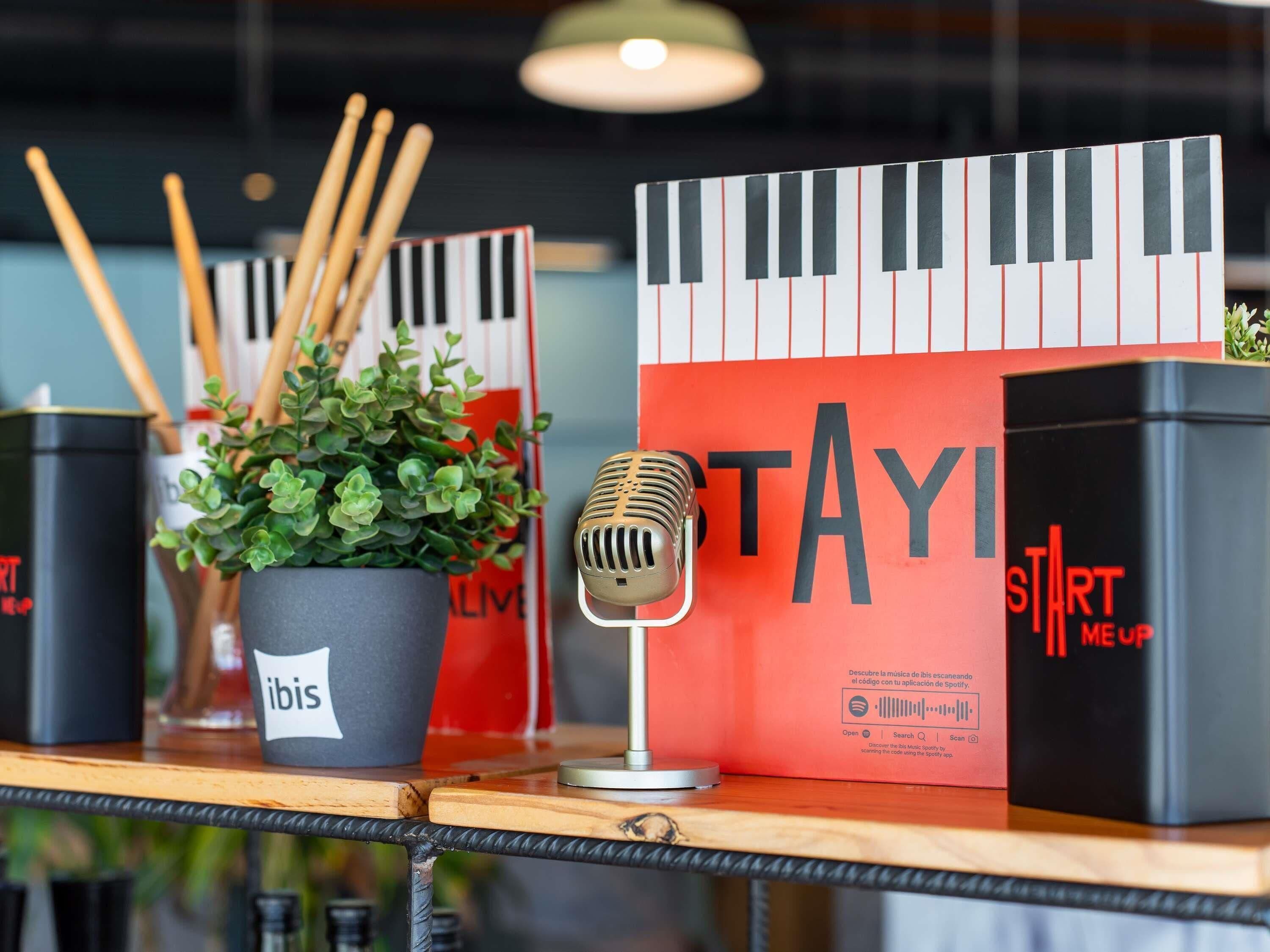 A microphone, a potted plant, and promotional materials on a table.