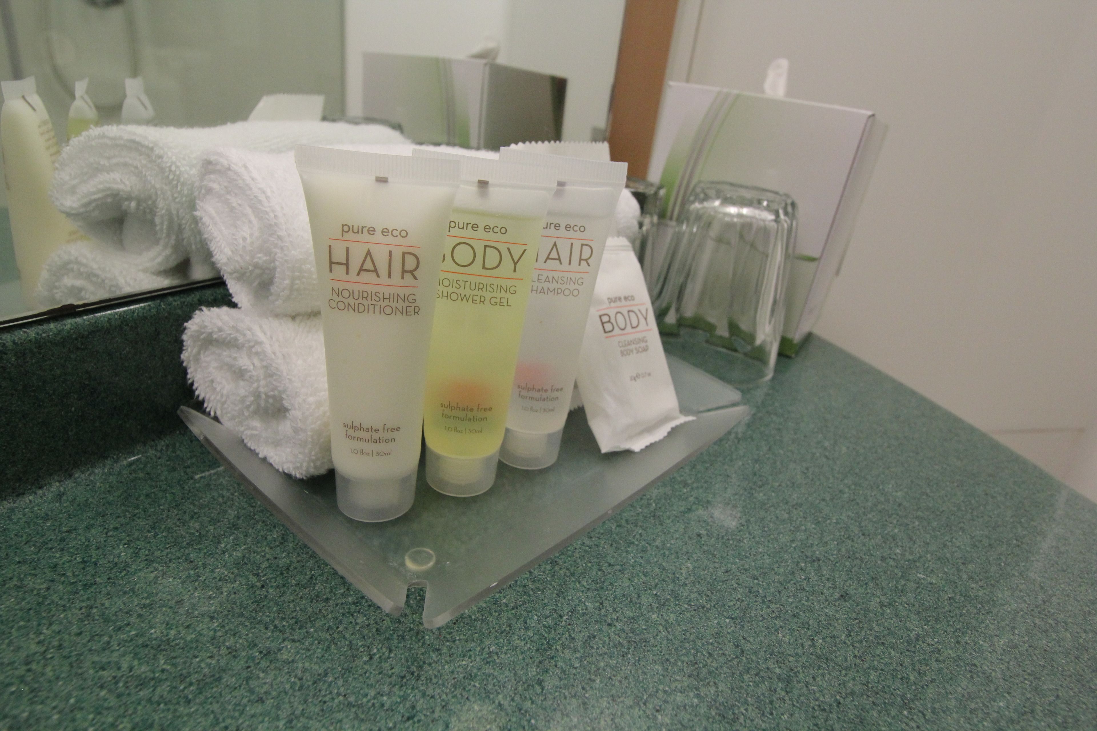Un meuble-lavabo de salle de bain avec divers produits de soins pour les cheveux et le corps.