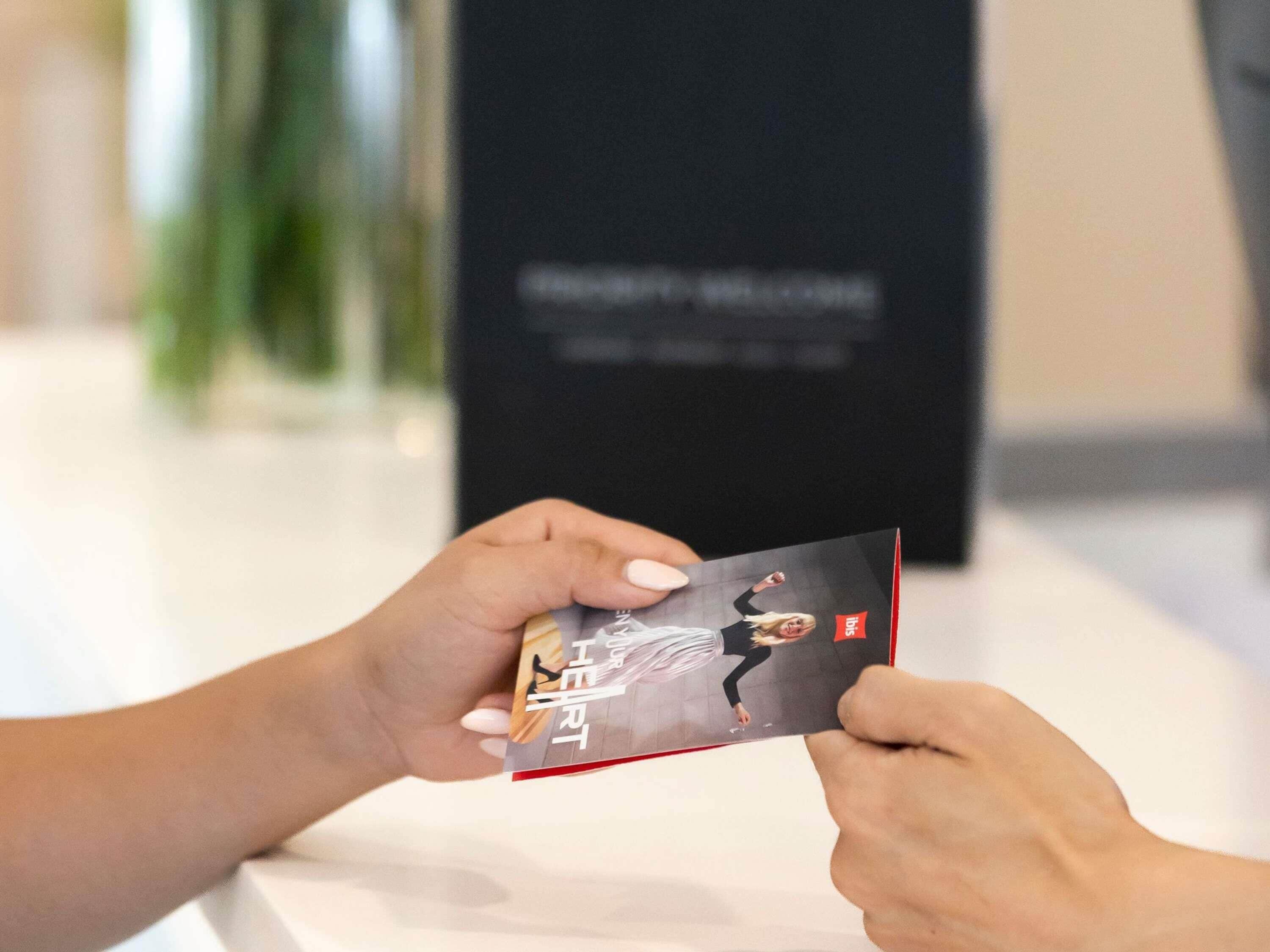 A person holding a brochure with a dancer on the cover.