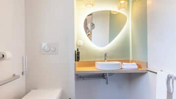 Une salle de bain moderne avec des toilettes, un lavabo et un miroir.