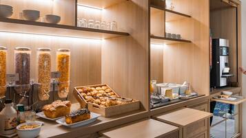 A breakfast bar with various food items and a coffee machine.