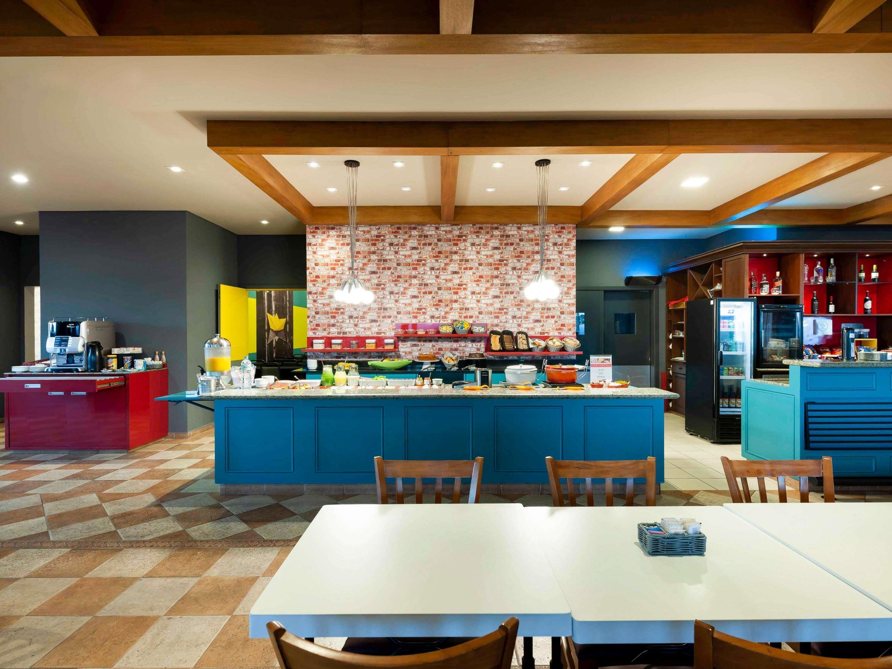 A modern kitchen with a central island, bar seating, and a dining area with a checkered floor.