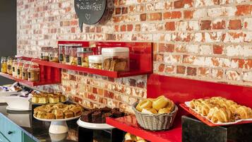 A buffet with various baked goods and a sign indicating gluten-free options.