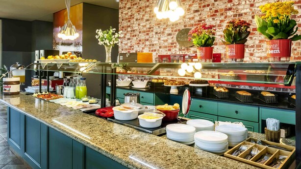 A buffet area with a variety of food items, a brick wall, and hanging lights. - ibis Sorocaba (Sorocaba)
