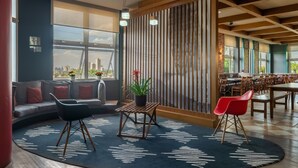 A modern lounge area with a sofa, chairs, a small table, and a potted plant. - ibis Sorocaba (Sorocaba)