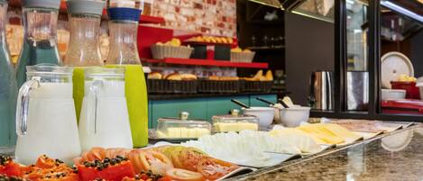 Un bufé de desayuno con diversas opciones de comida y bebidas.