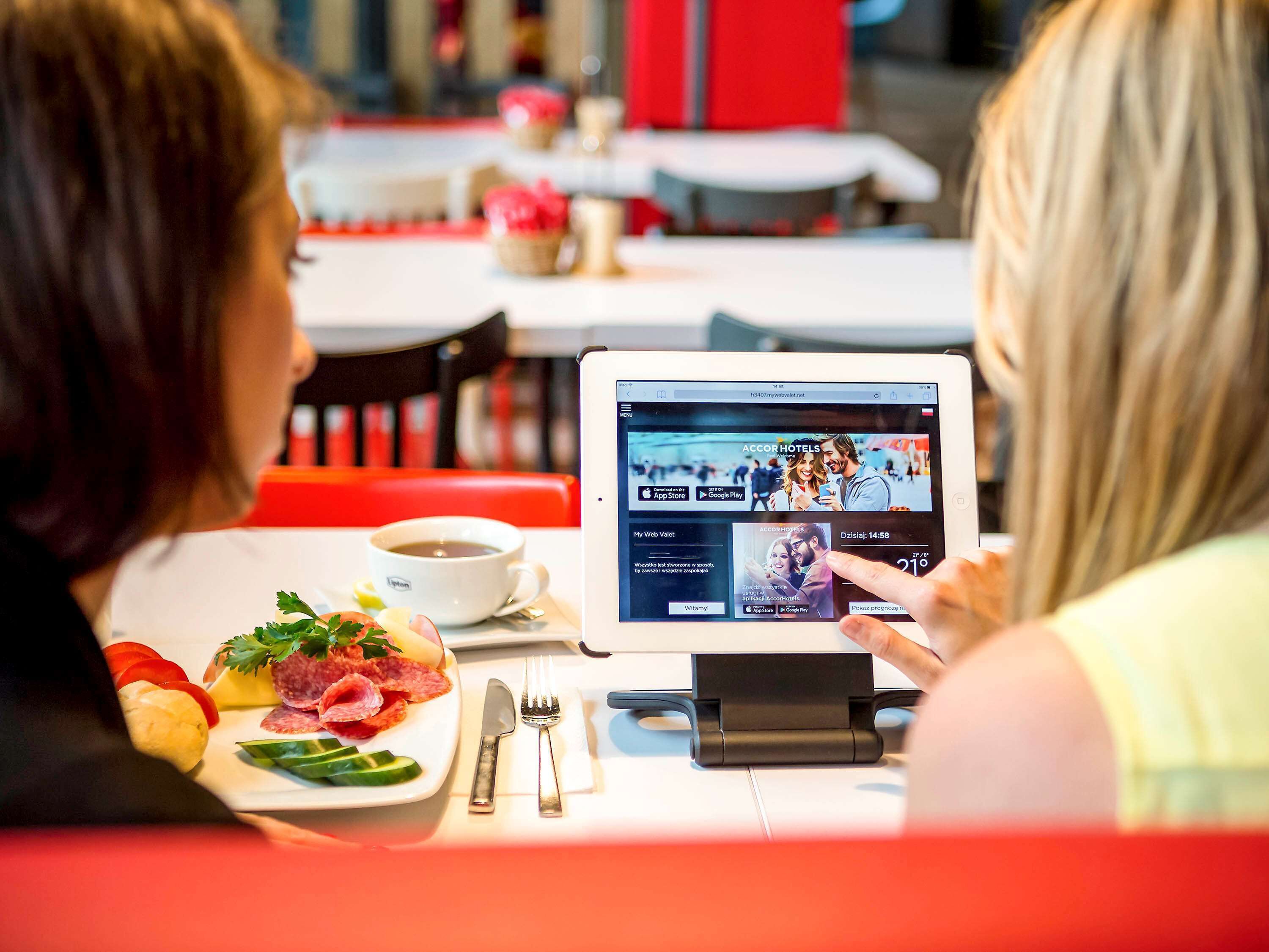 A tablet displaying a hotel website with a menu and a booking option.