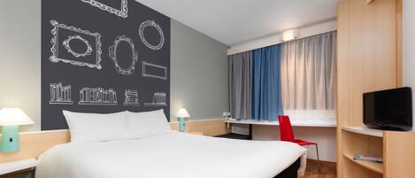 Habitación de hotel con una cama grande, mesitas de noche con lámparas, un escritorio, una silla, un televisor y un armario.