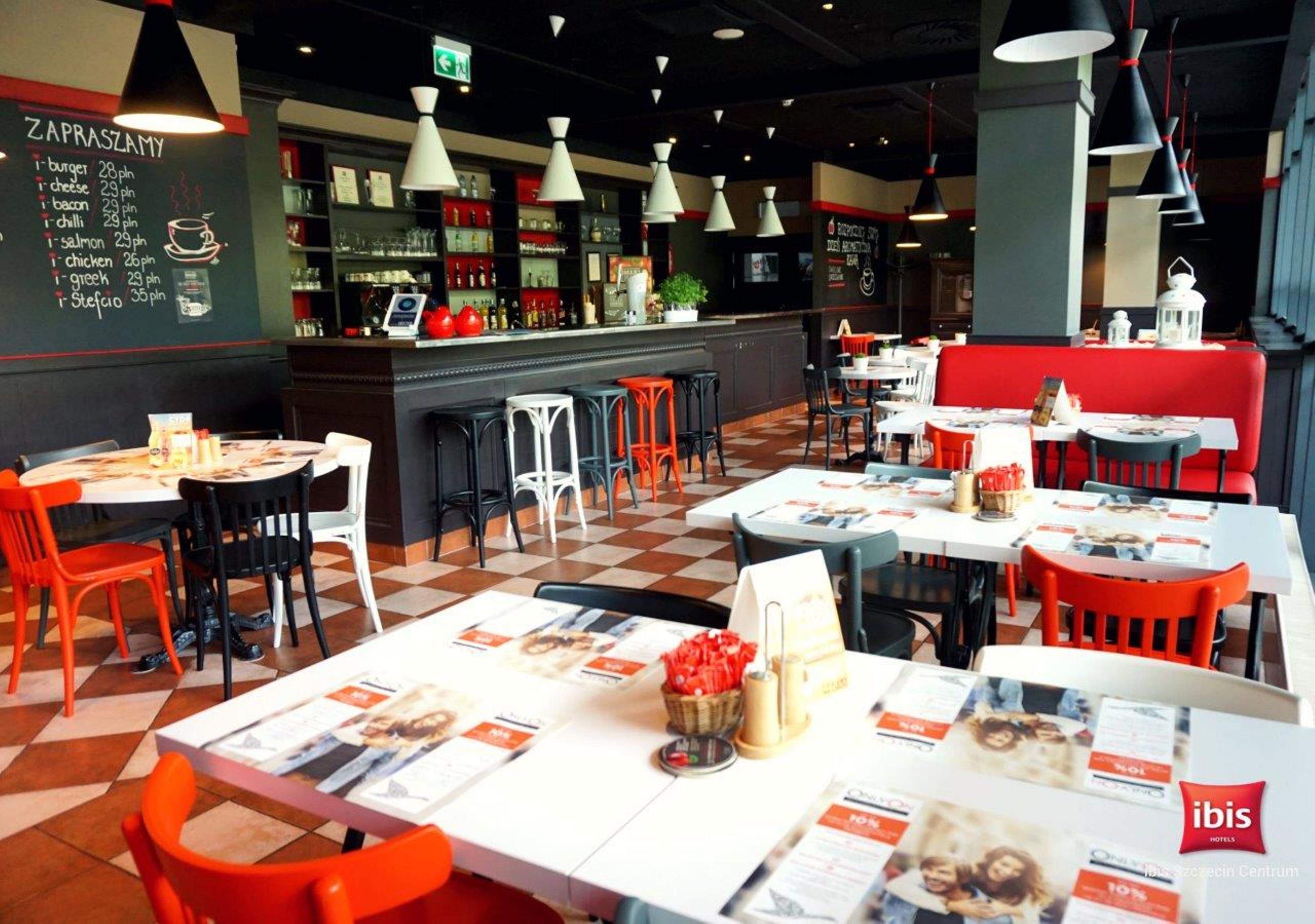Een restaurant met tafels, stoelen, een menukaart en een bar.