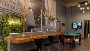 A pool table, bar area, and seating in a room with a large wall mural and a neon sign. - ibis Paulinia (Paulinia)