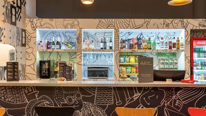 A bar area with shelves of beverages, a menu board, and a Coca-Cola refrigerator. - ibis Paulinia (Paulinia)