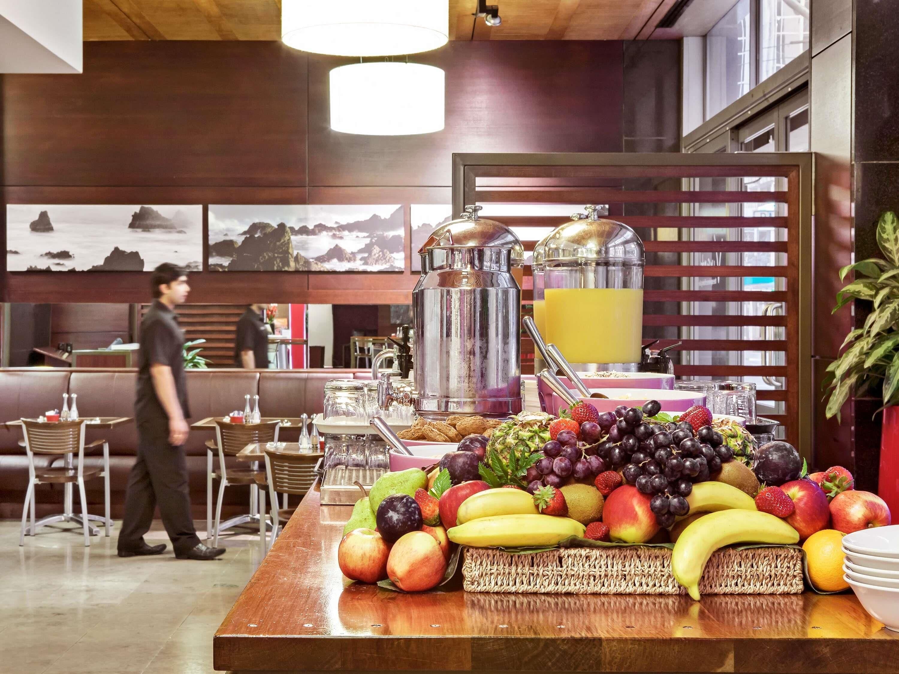 Een ontbijtbuffet met verschillende soorten fruit en een koffiehoek.