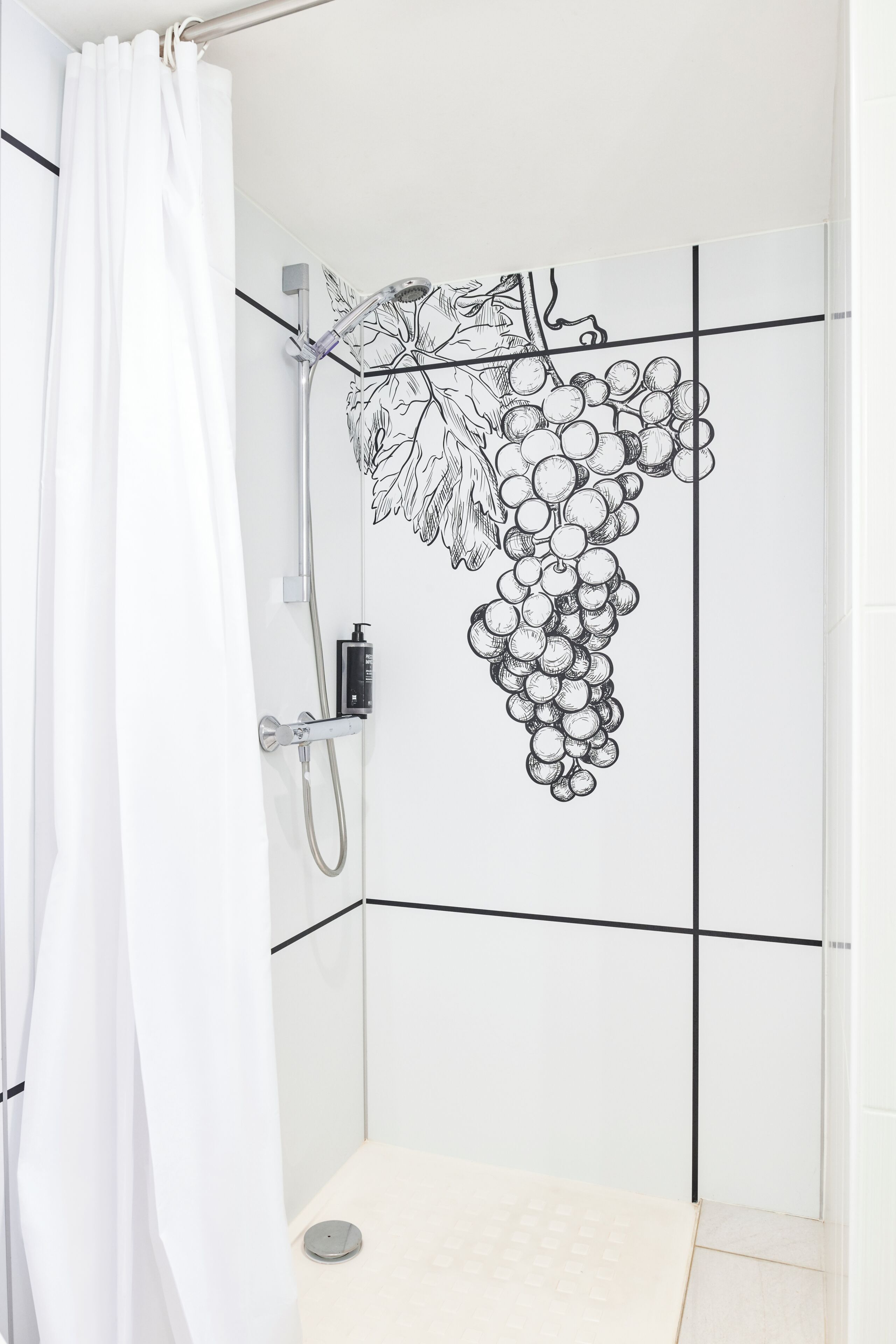 A shower with a white curtain, a handheld showerhead, and a wall-mounted faucet.