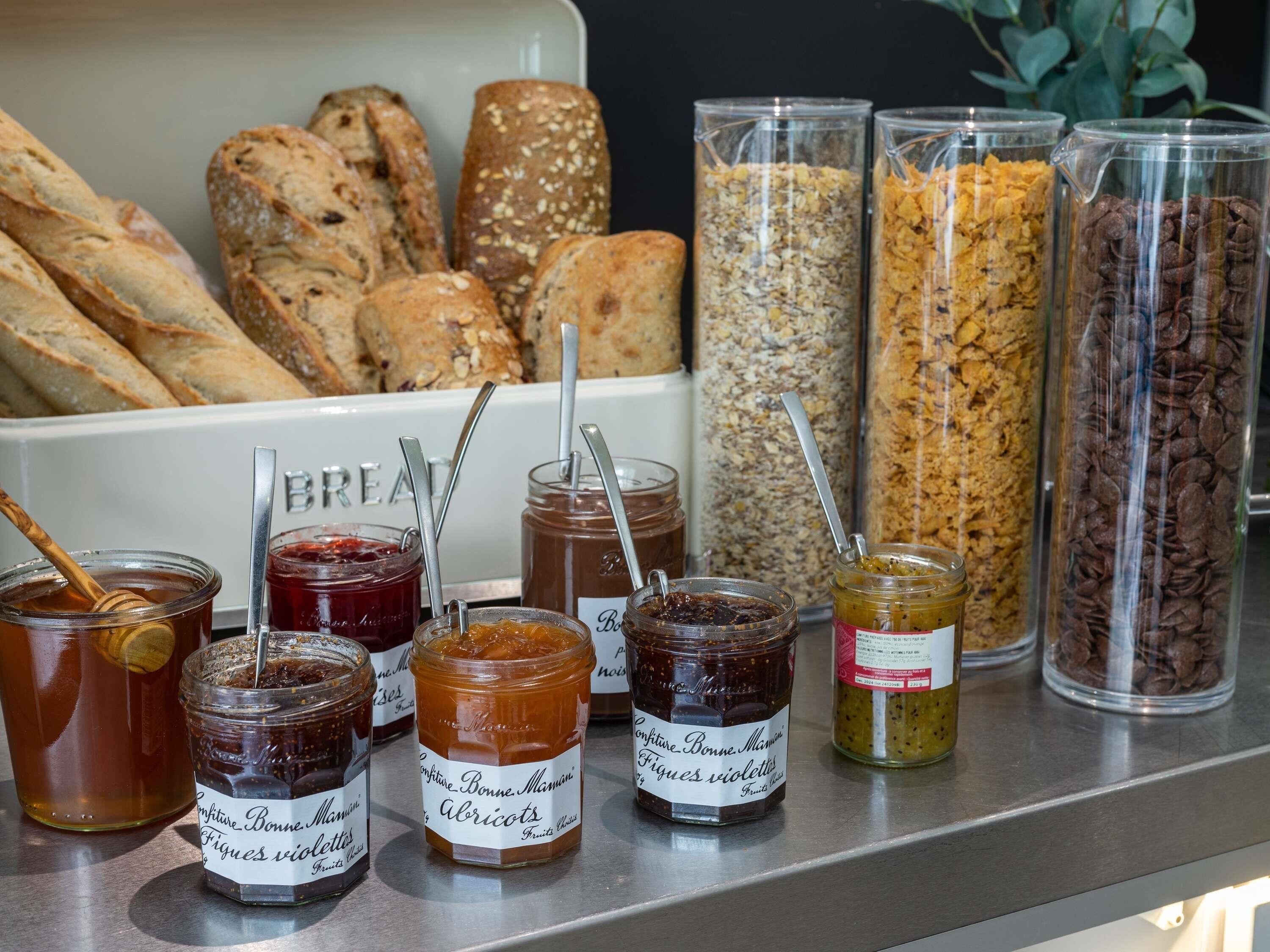 A variety of food items including jars of preserves, granola, and bread.