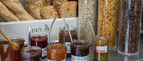 A variety of food items including jars of preserves, granola, and bread.