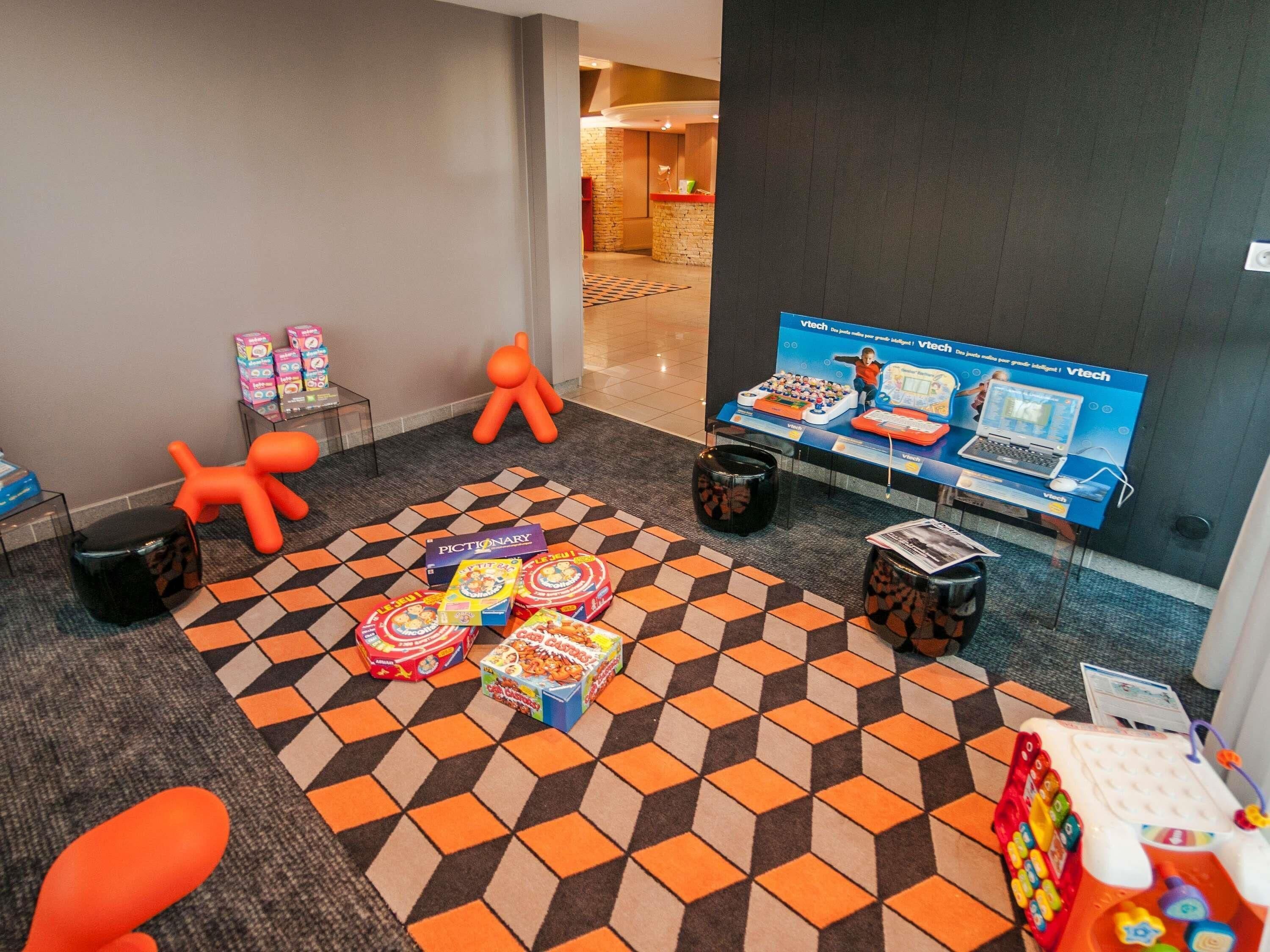 A lobby with a checkered carpet, a reception desk, and a display of children's toys.