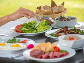 A table with various dishes including bread, salad, and meats, suggesting a meal setting. - Mercure Ismailia Forsan Island Hotel (Ismailia)