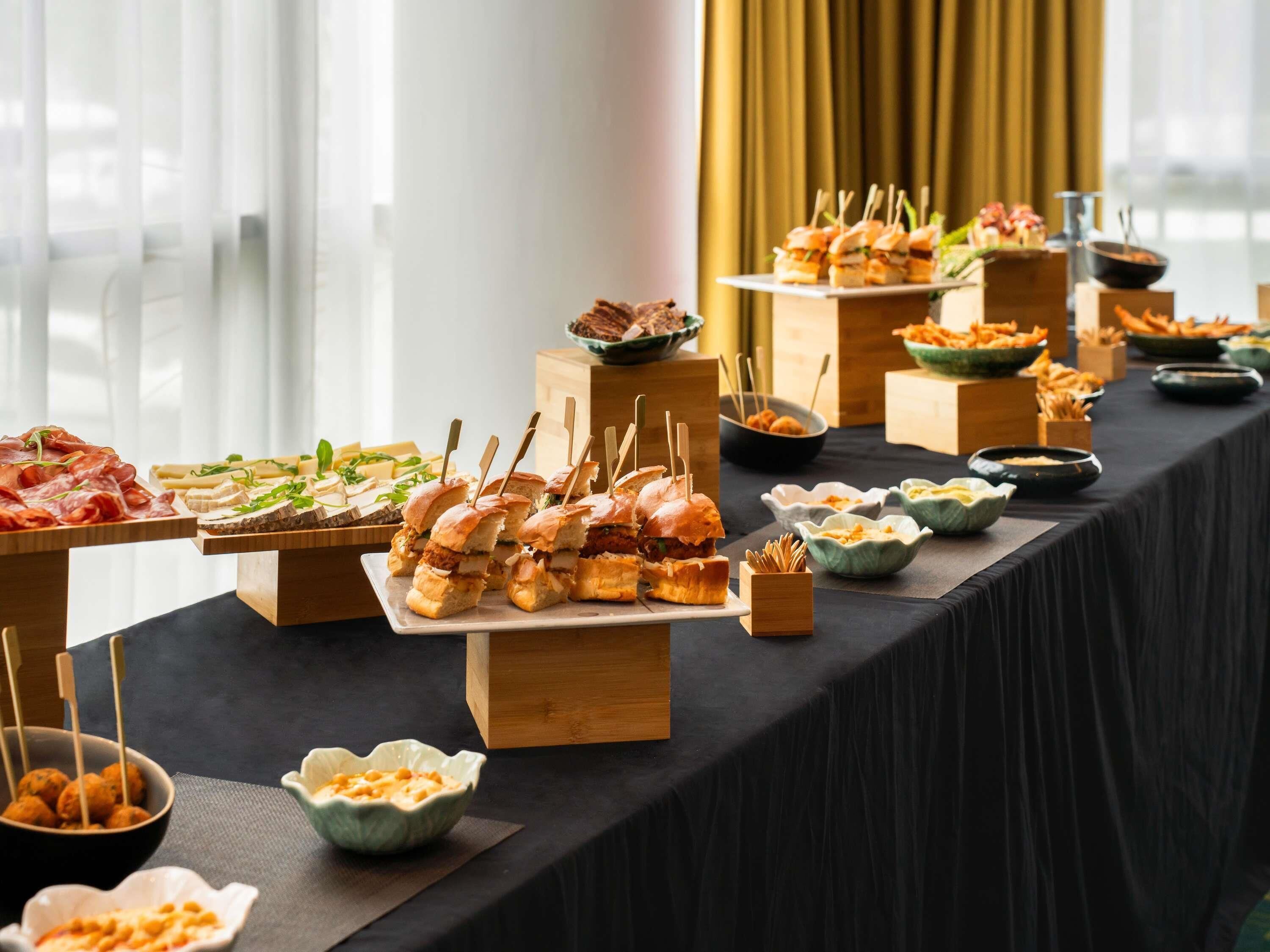 A buffet table with various food items and wooden serving boards.
