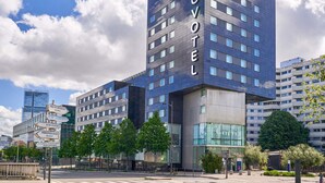 Un hôtel moderne, reconnaissable à son grand panneau « NOVOTEL », à ses nombreux étages et à sa façade en verre.