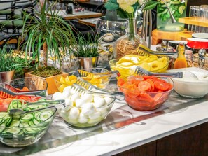 Un bufé con diversos alimentos y utensilios.