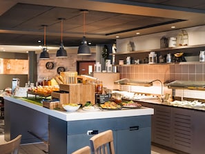 A buffet setup with various food items and a wooden counter.