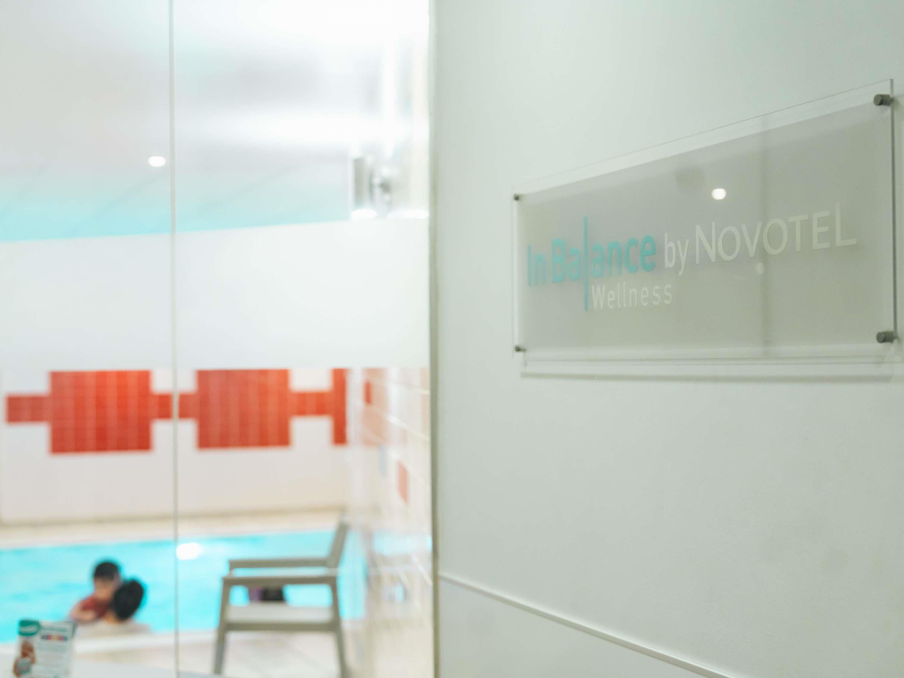 A sign reading "In Balance by NOVOTEL Wellness" in a hotel setting.