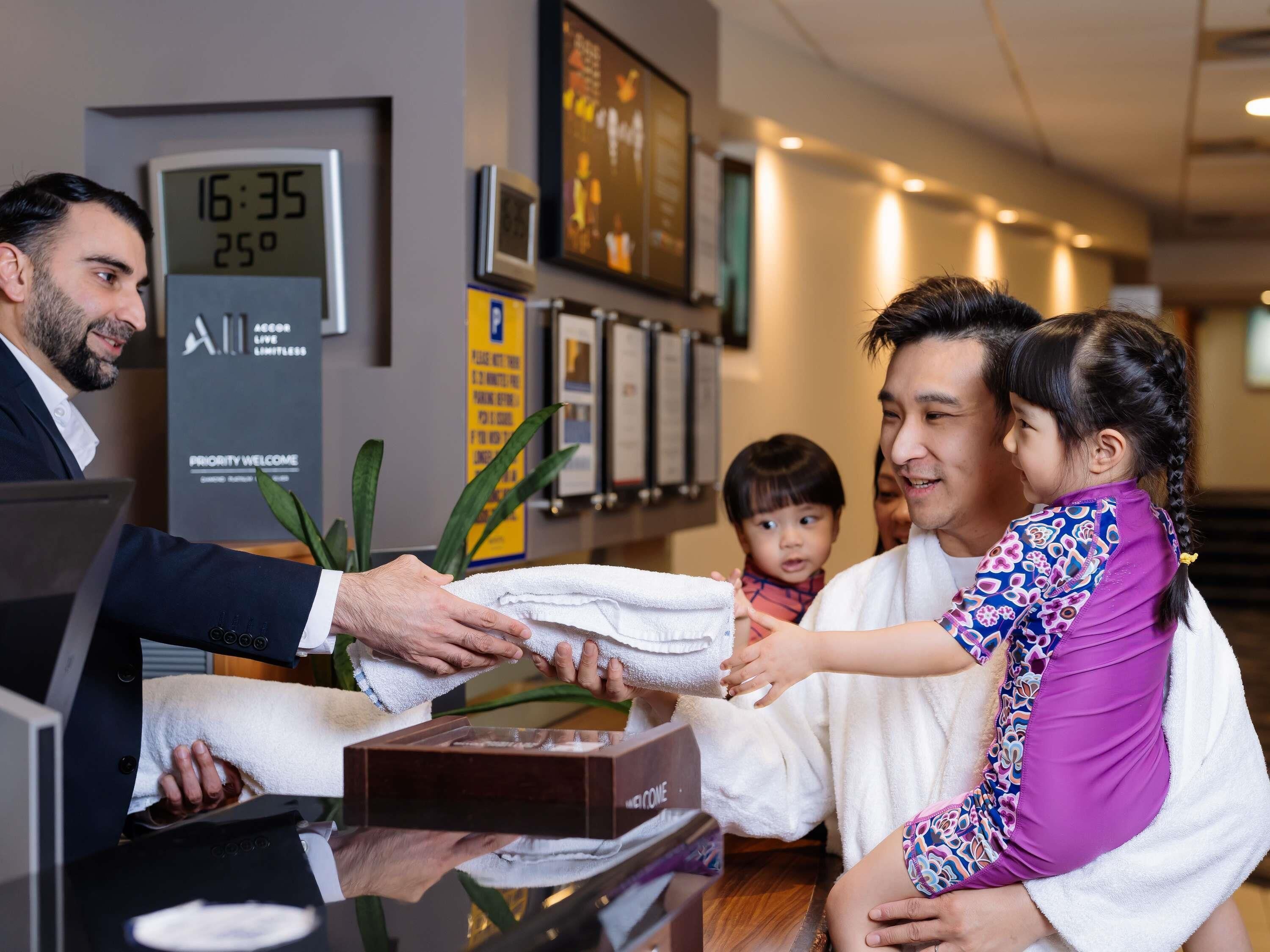 A hotel reception area with a digital clock displaying the time and temperature.