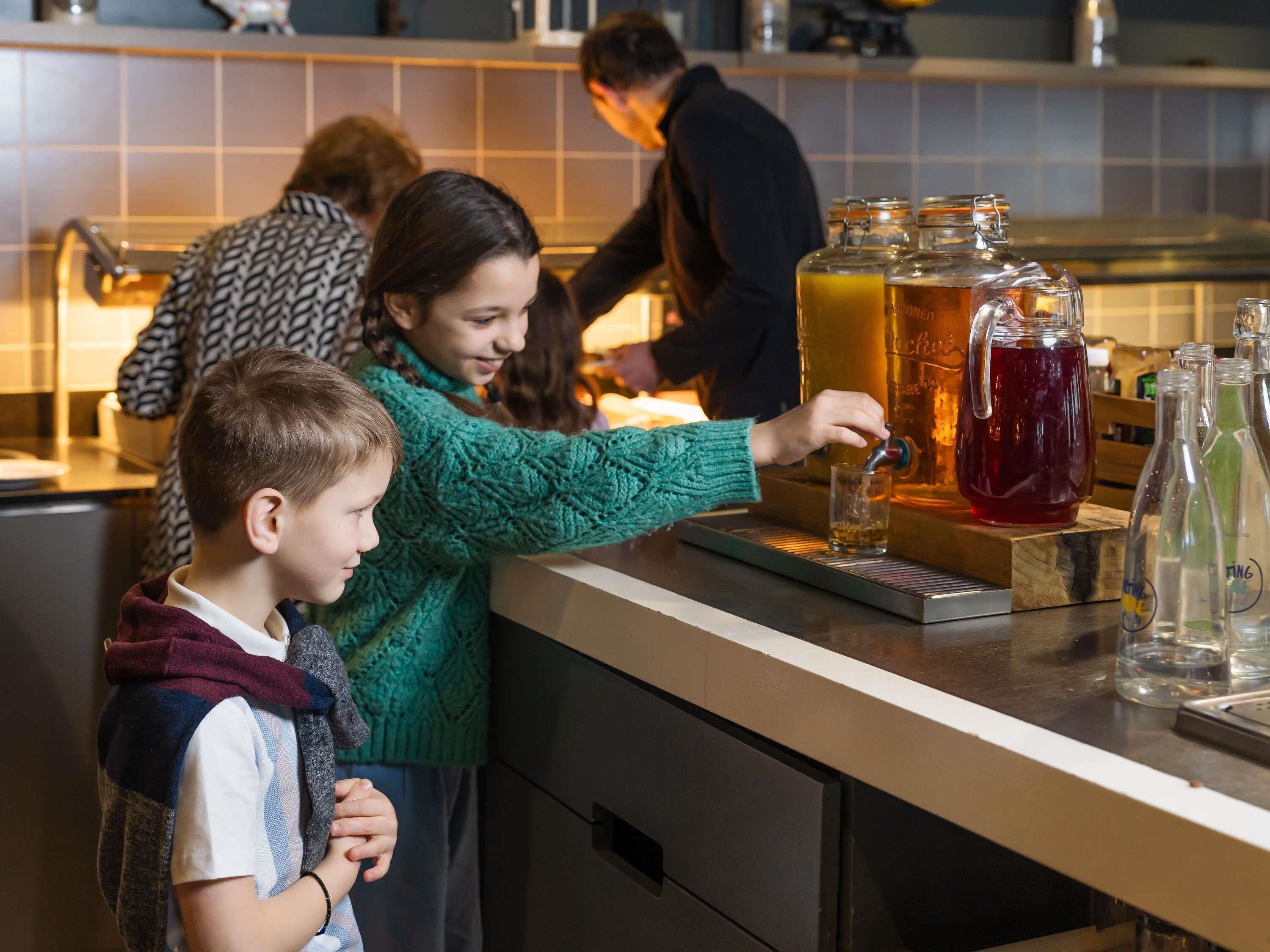 A bar area with a tap and glassware, a person pouring a drink, and a counter with bottles.