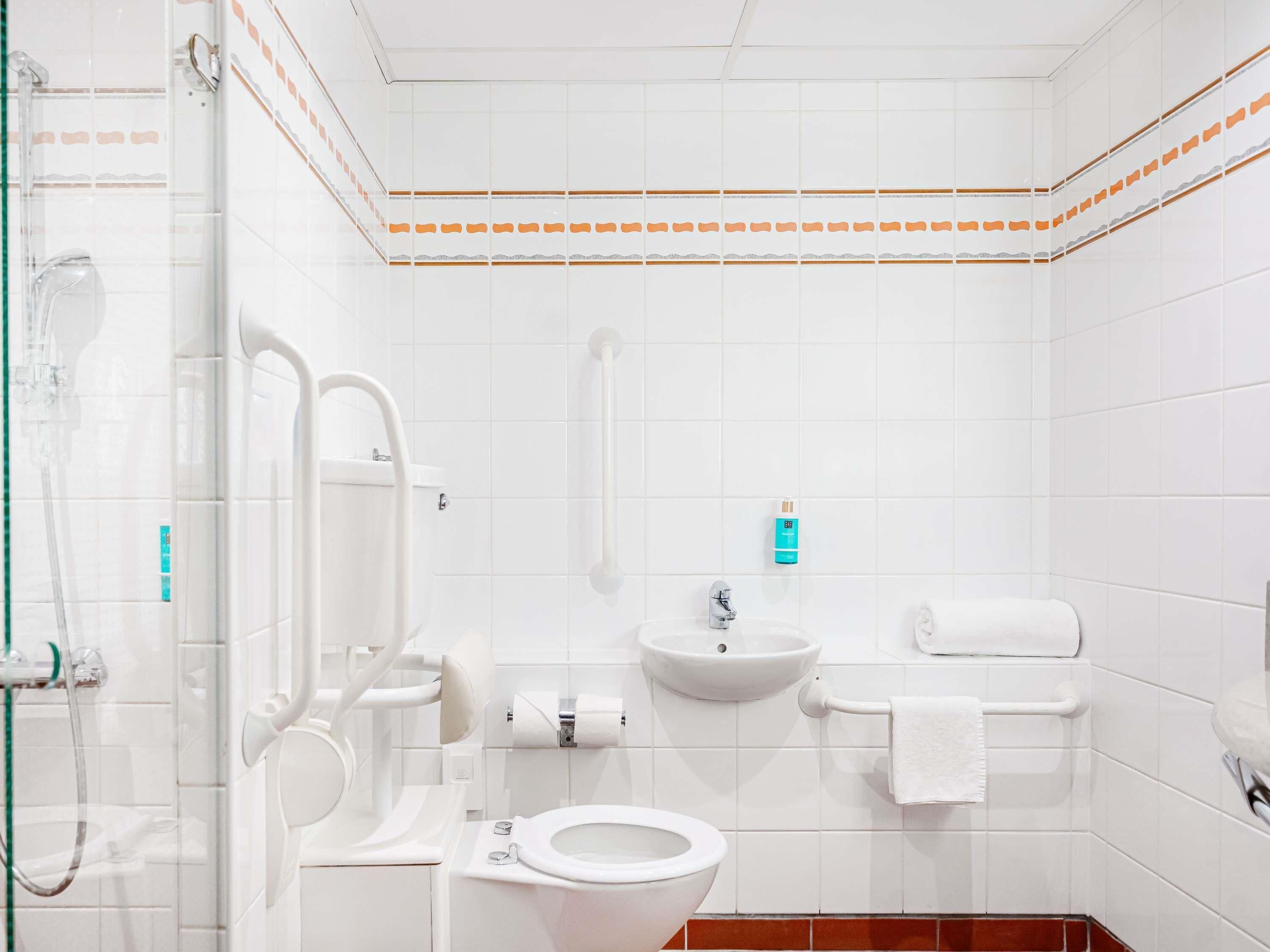 Ein modernes Badezimmer mit Toilette, Waschbecken und Dusche.
