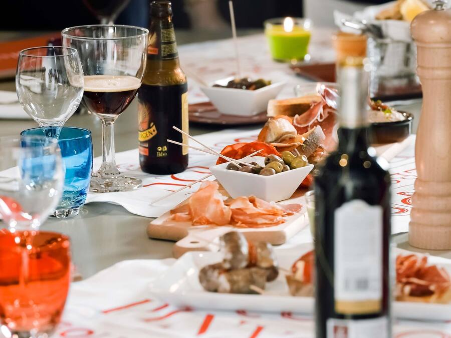 Uma mesa posta com diversos alimentos, copos e garrafas.