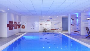 A swimming pool with tiled walls, a lifebuoy, and a lounge chair. - Novotel Milton Keynes (Milton Keynes)