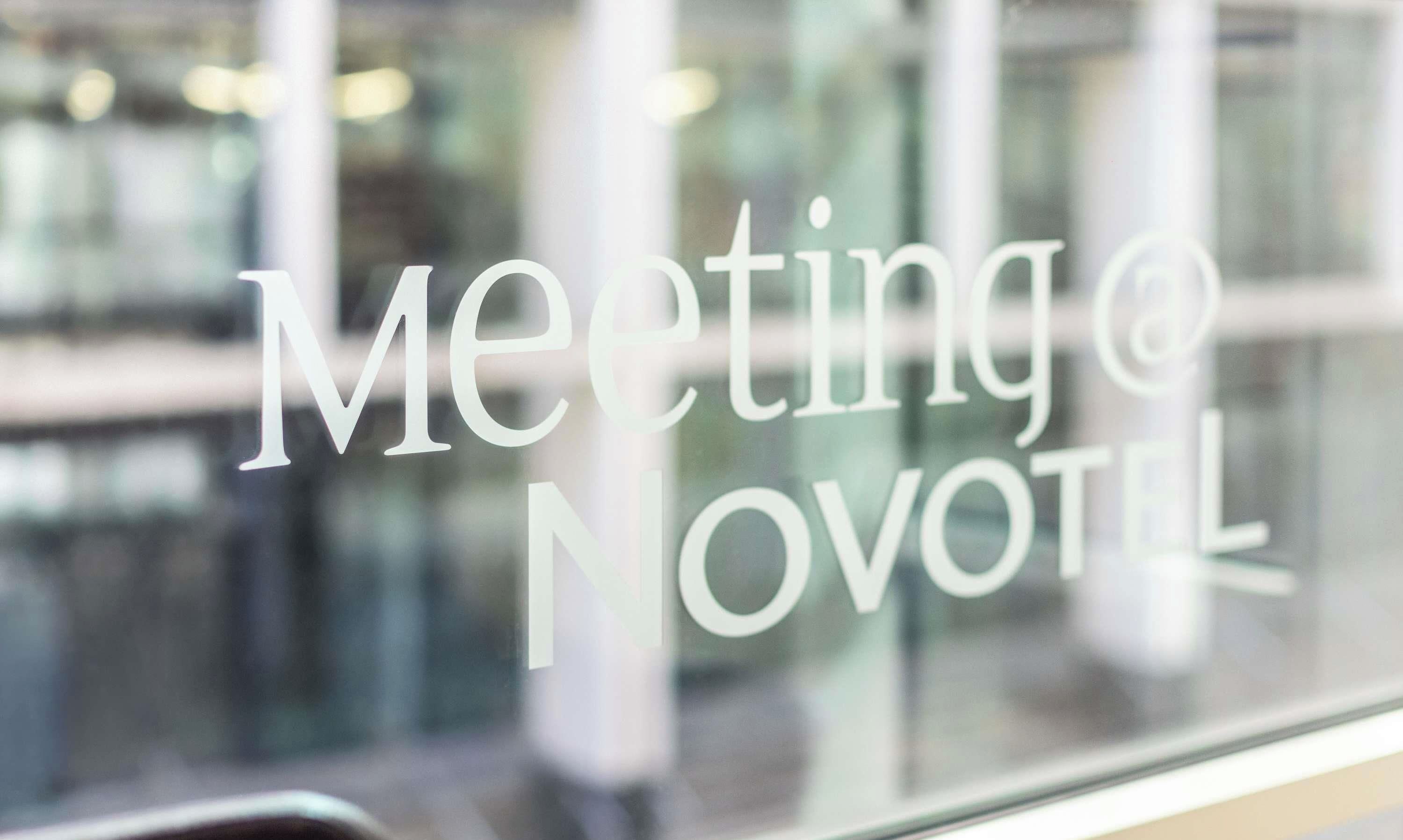 Une fenêtre sur laquelle est inscrit en caractères clairs et sans empattement : « Réunion NOVOTEL ».