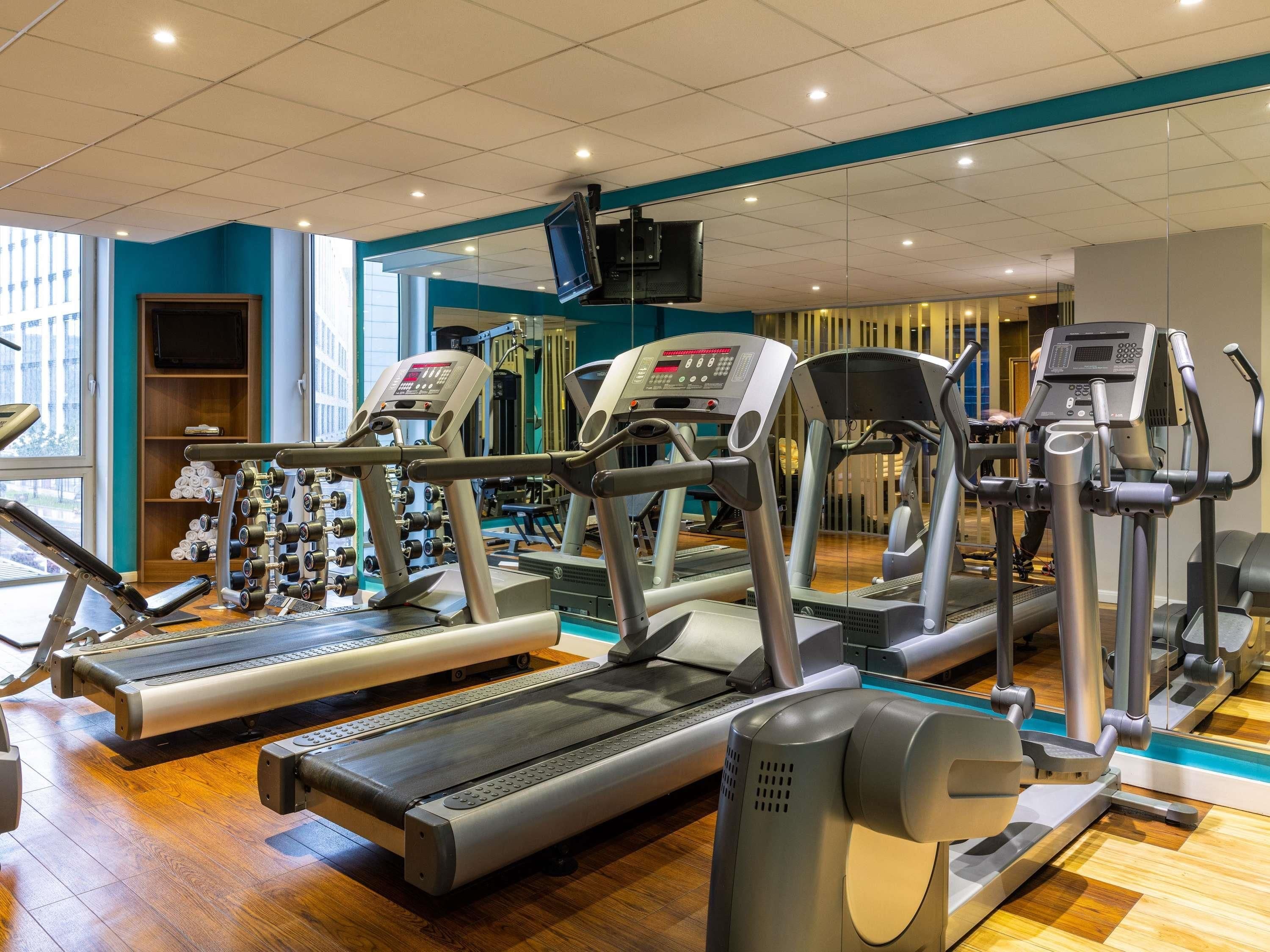 A gym with treadmills, elliptical machines, and weight machines.