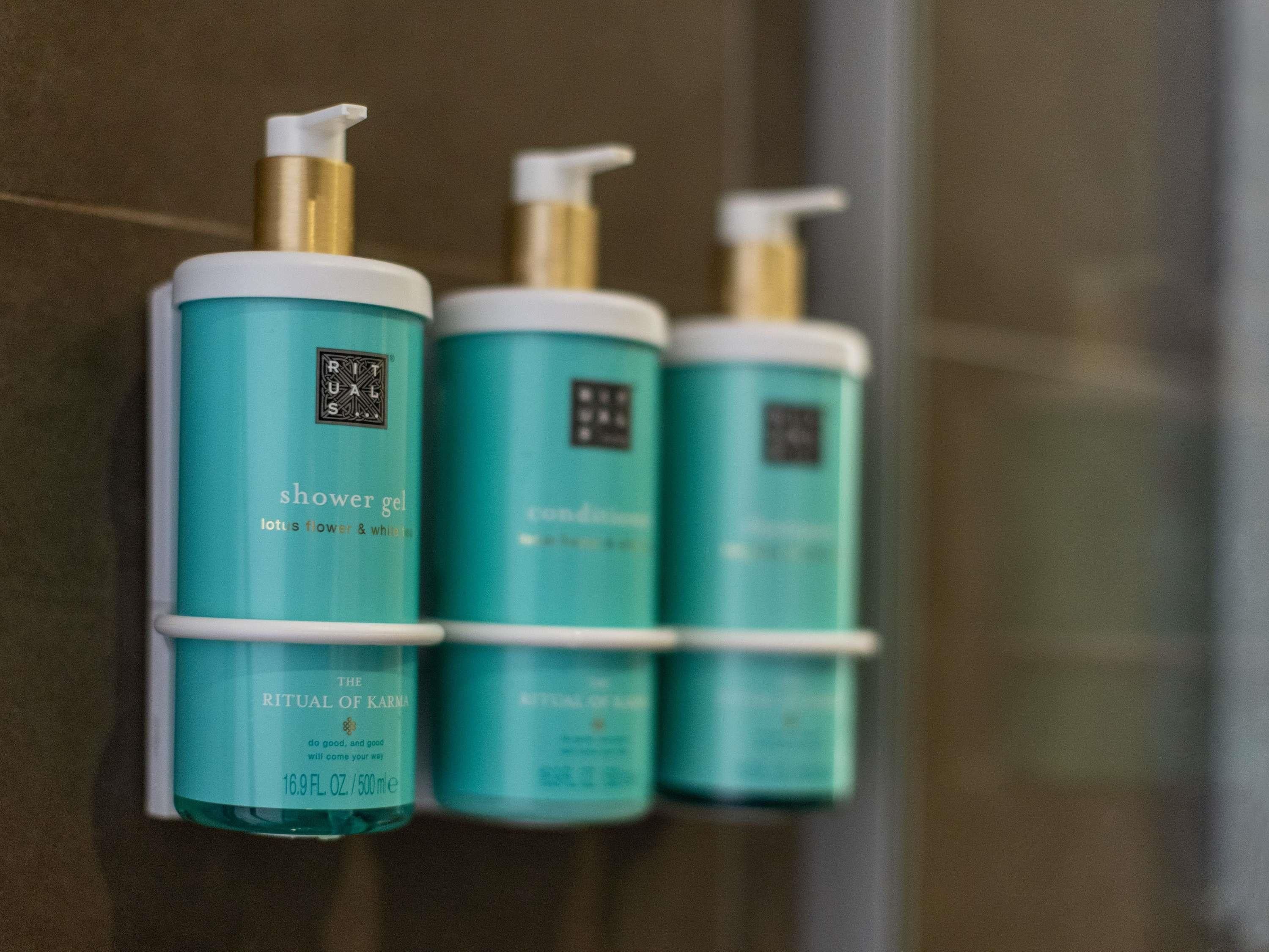 Three bottles of shower gel on a wall.