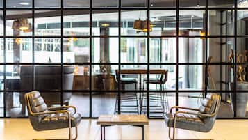 A modern interior with leather chairs, a wooden table, and pendant lighting.