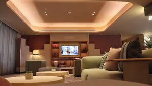 Un salon moderne doté d’un téléviseur à écran plat, de sièges confortables et d’un éclairage d’ambiance.