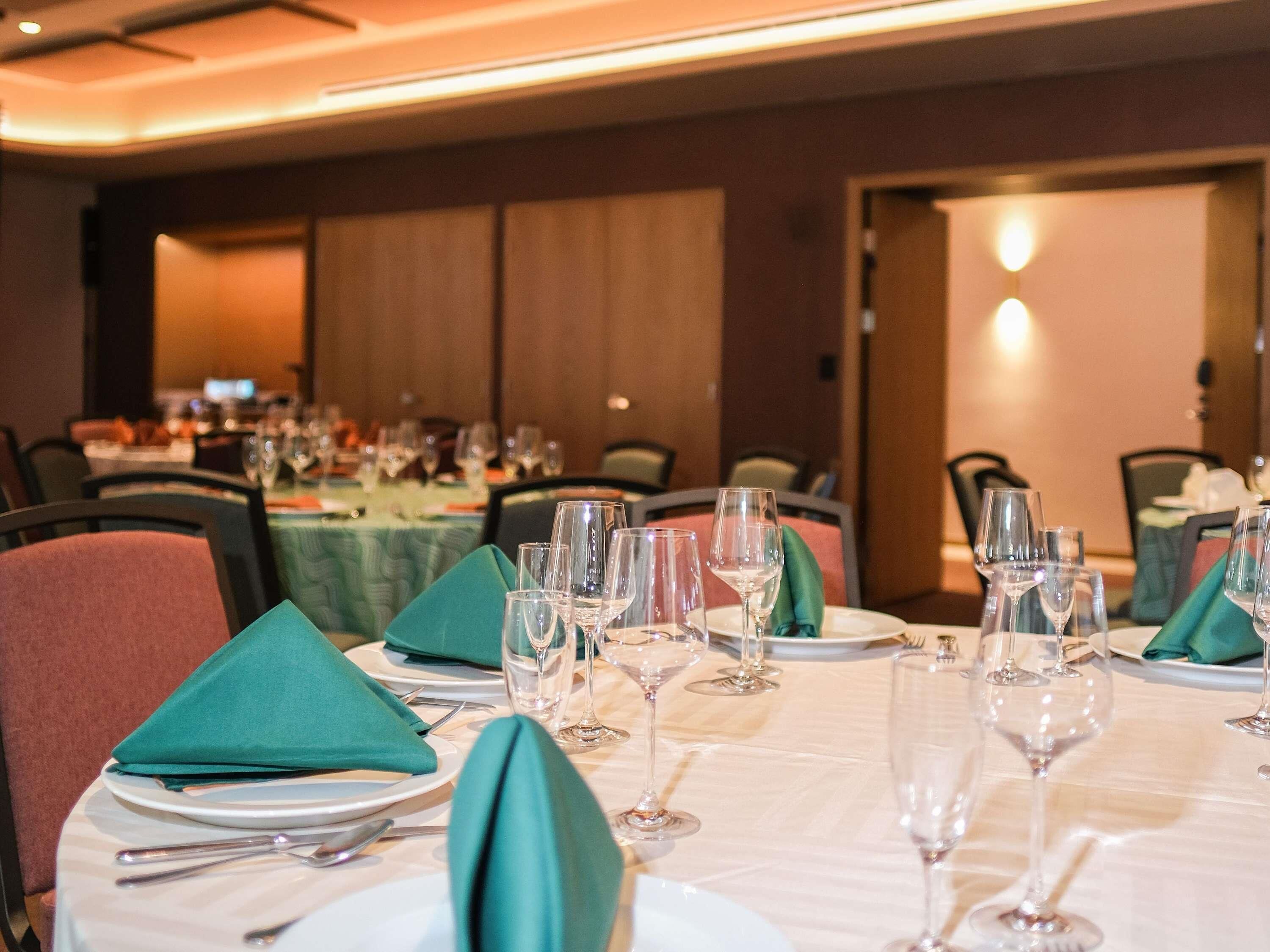 A dining area with tables set for a meal, chairs, and a view of the room.