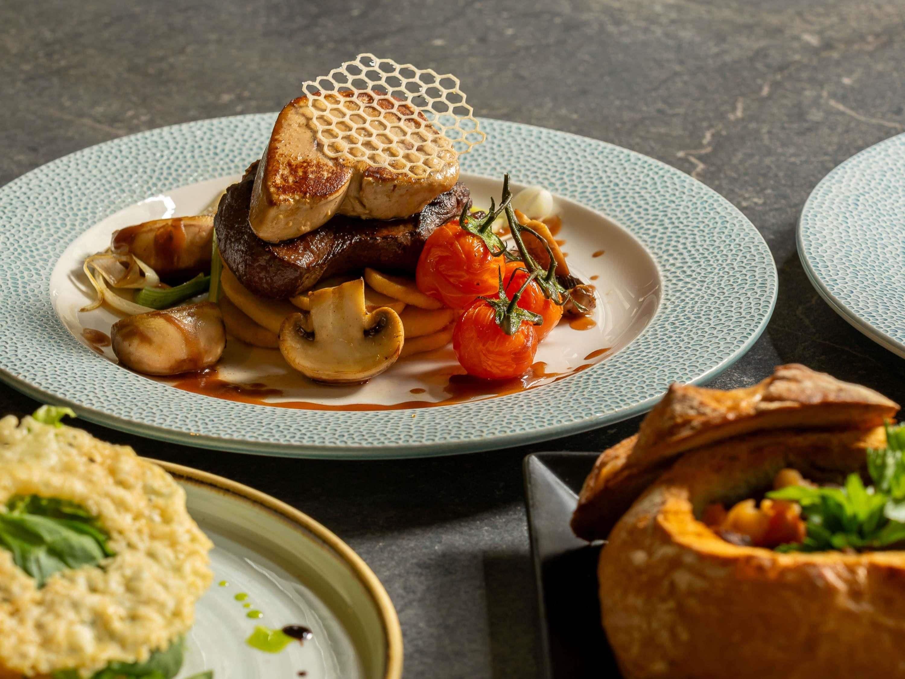 A plate with food, a bowl, and a pastry.
