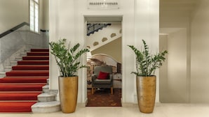A staircase with red carpet leading to a reading area labeled 'READERS' CORNER'. - Mövenpick Hotel Budapest Centre (Budapest)