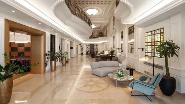 A spacious lobby with a high ceiling, a central seating area, and a staircase leading to upper floors. - Mövenpick Hotel Budapest Centre (Budapest)
