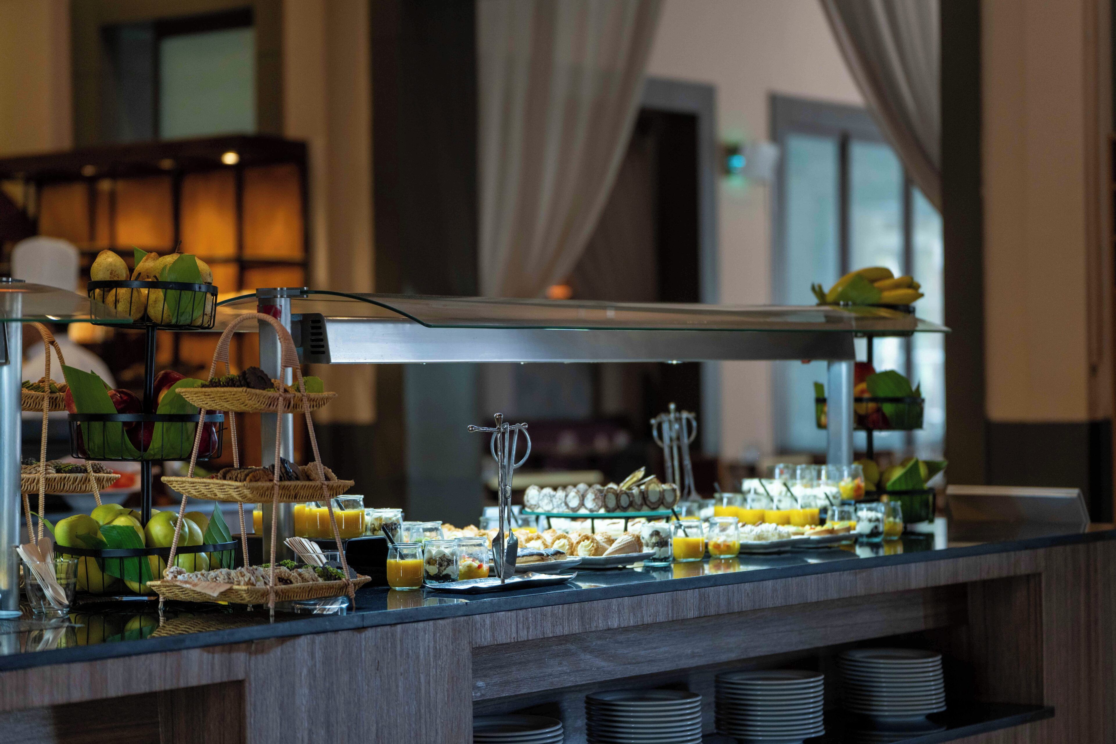 A buffet with various food items and a glass display case.
