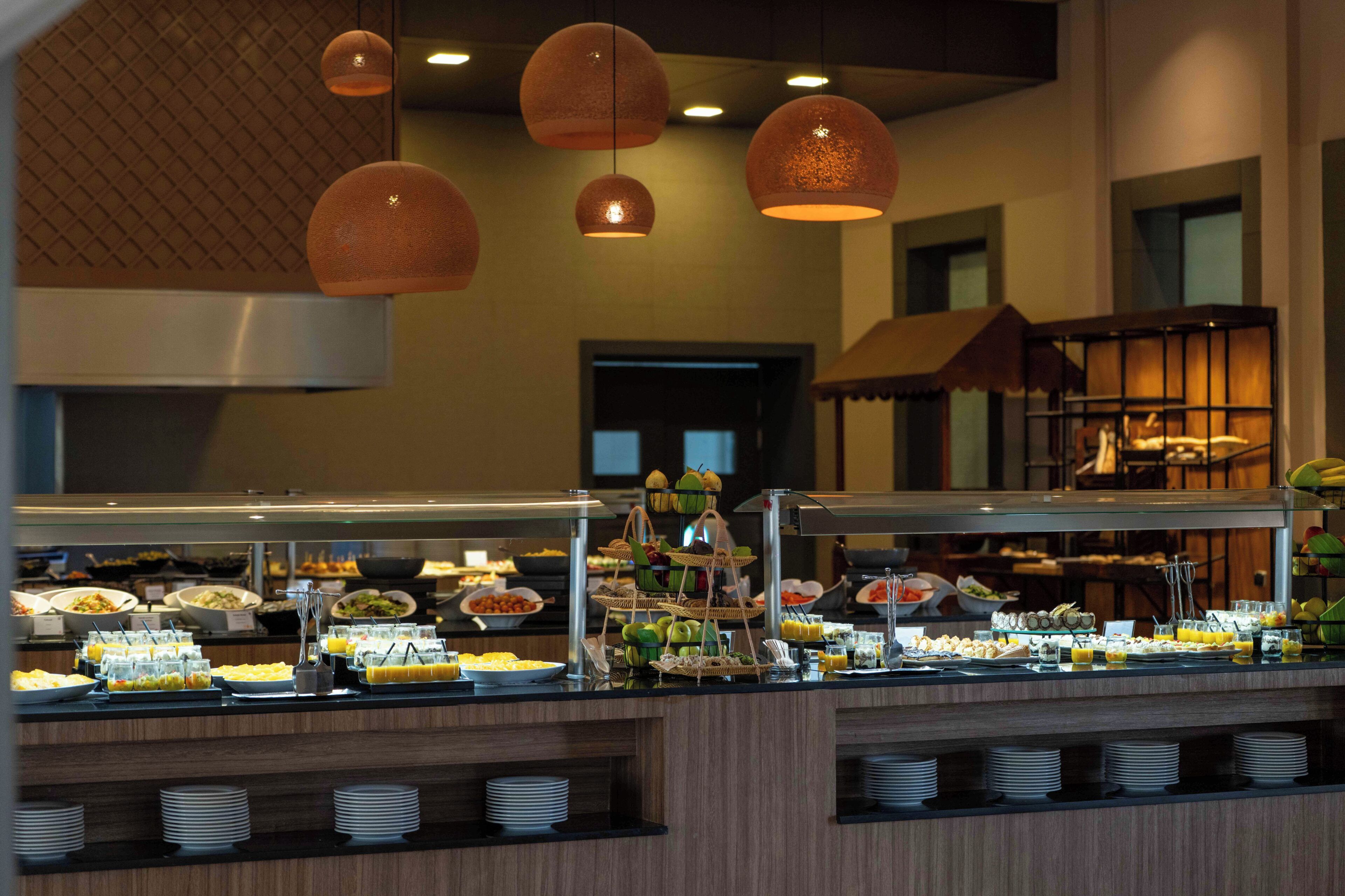 A buffet with various food items and a glass display case.