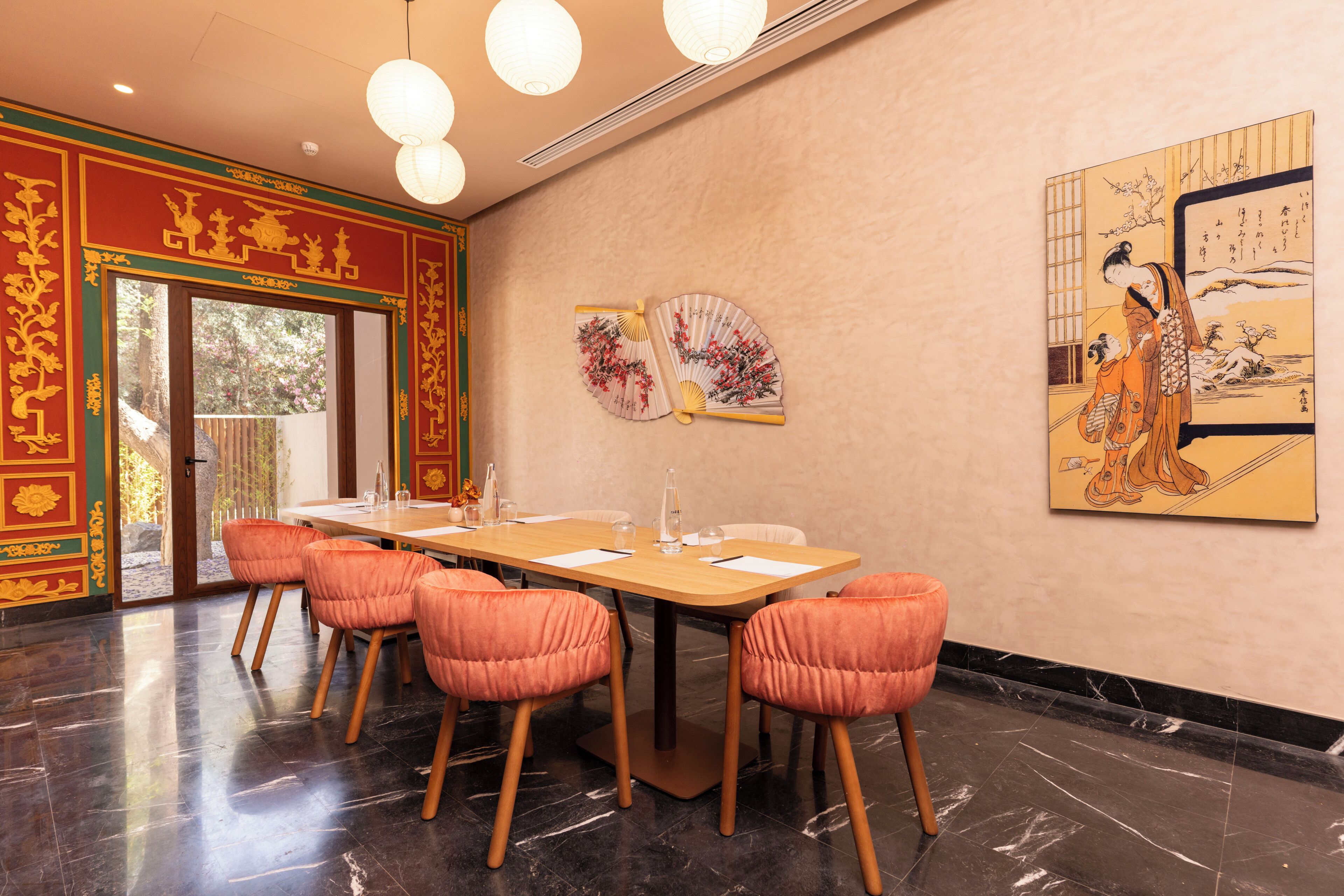 A conference room with a long table, six chairs, and two wall-mounted fans.