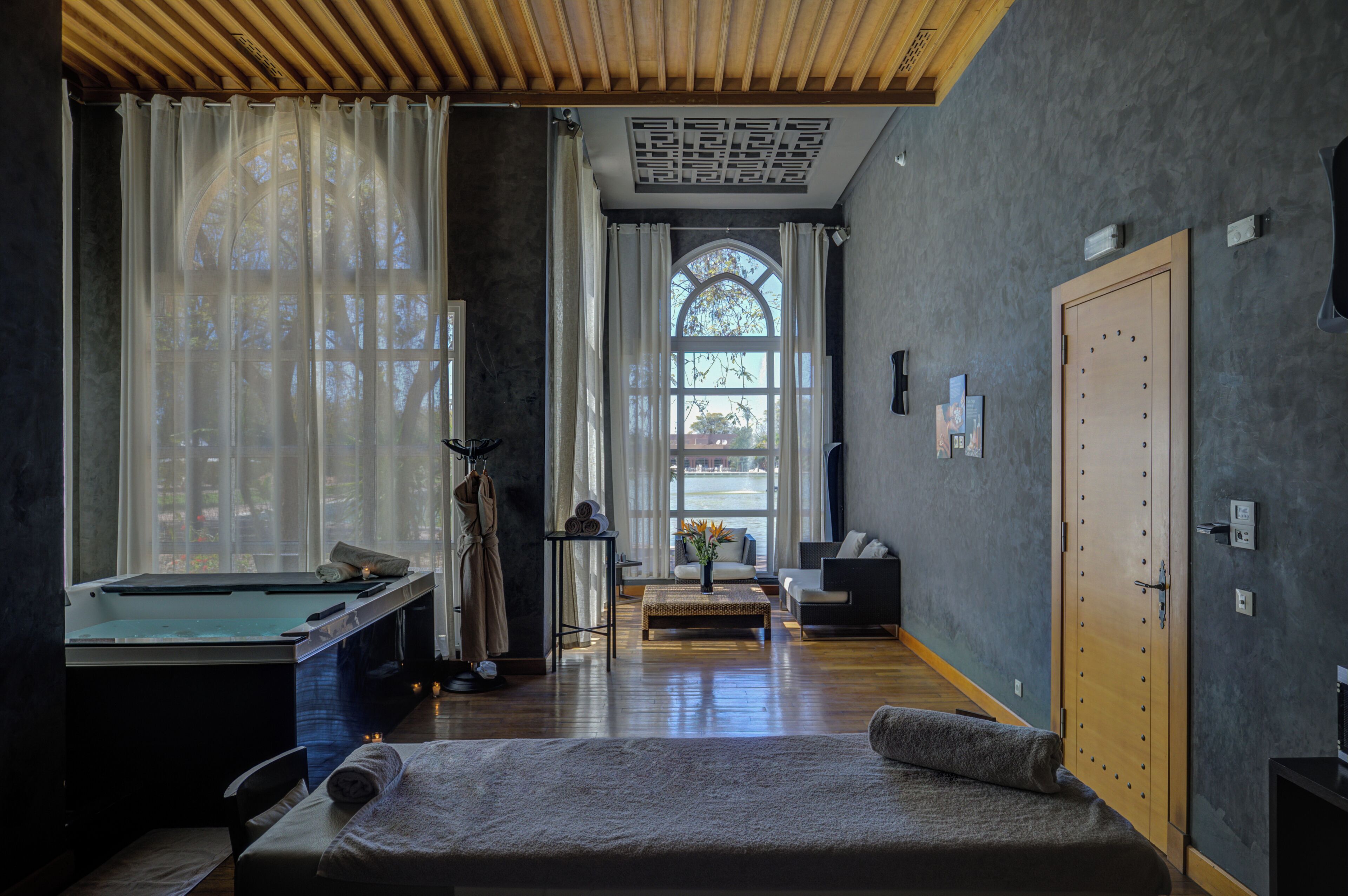 Una habitación con mesa de billar, sillón de masaje, ventana con cortinas y puerta con cerradura.