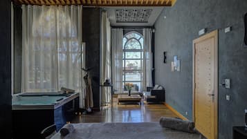 A room with a pool table, a massage chair, a window with curtains, and a door with a lock.
