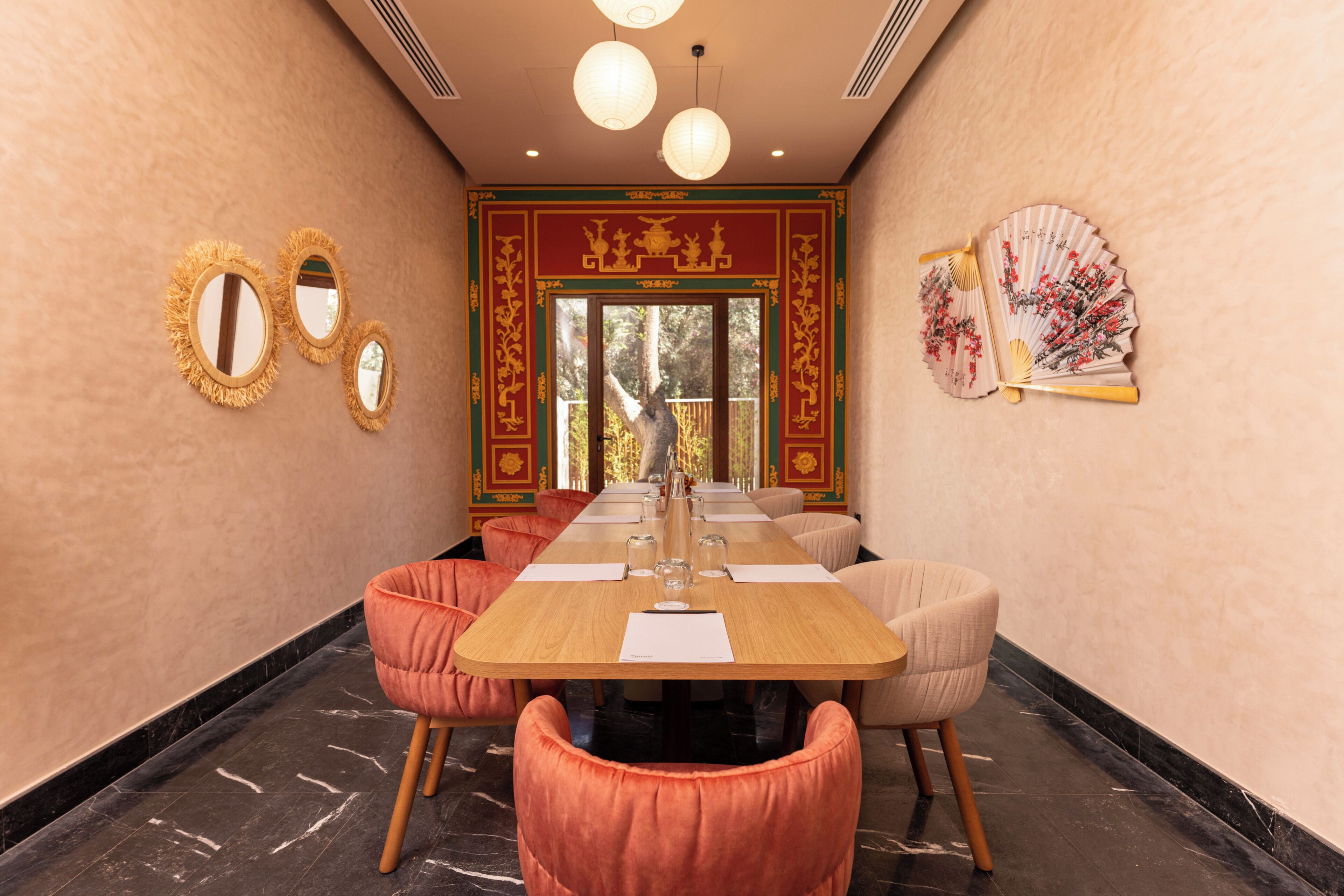 A conference room with a long table, multiple chairs, and decorative wall elements.