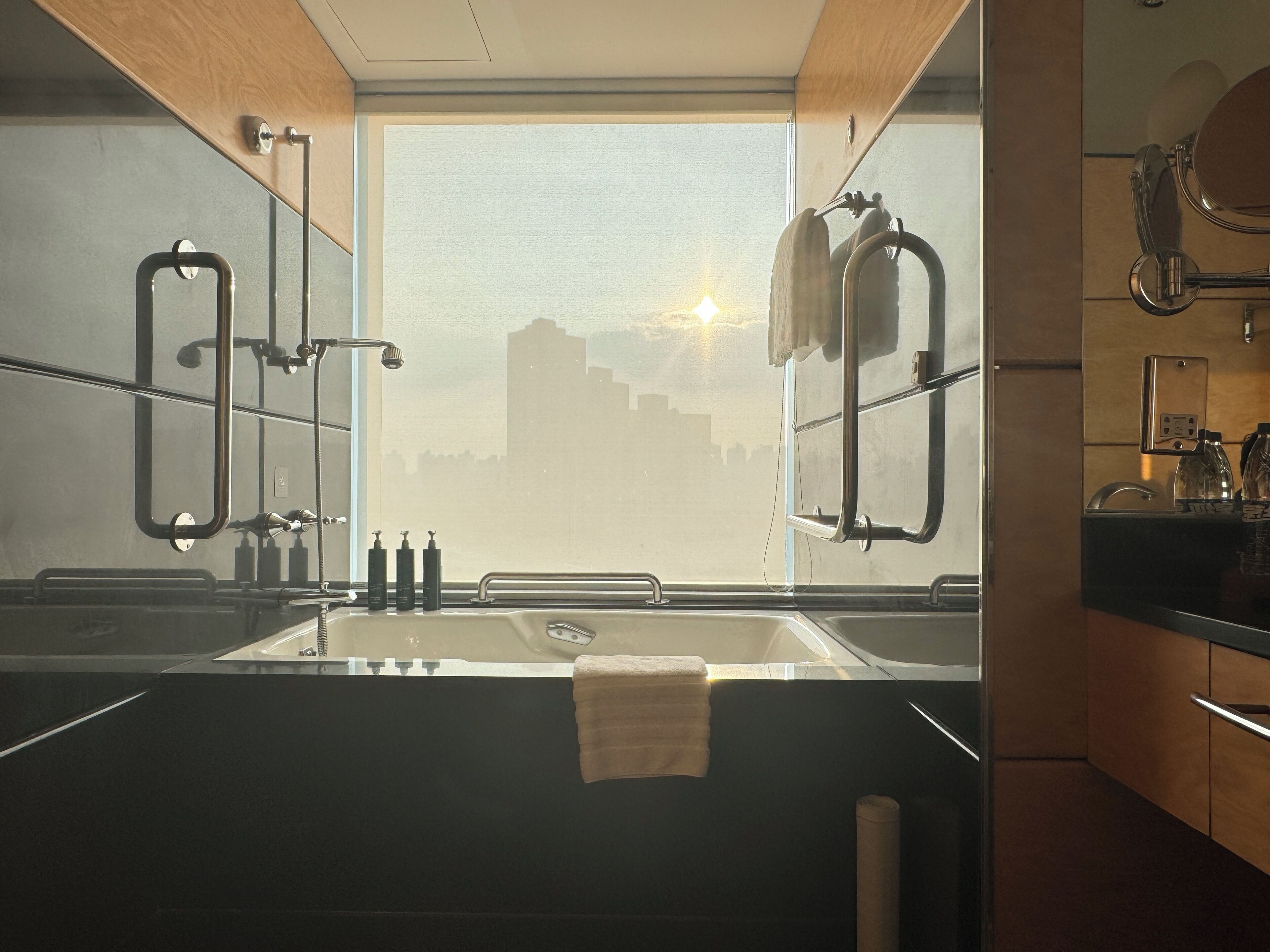Une salle de bain moderne avec une grande fenêtre, un lavabo et un porte-serviettes.
