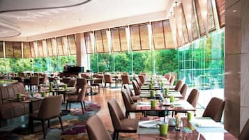 A spacious dining area with high ceilings, large windows, and a variety of seating arrangements.