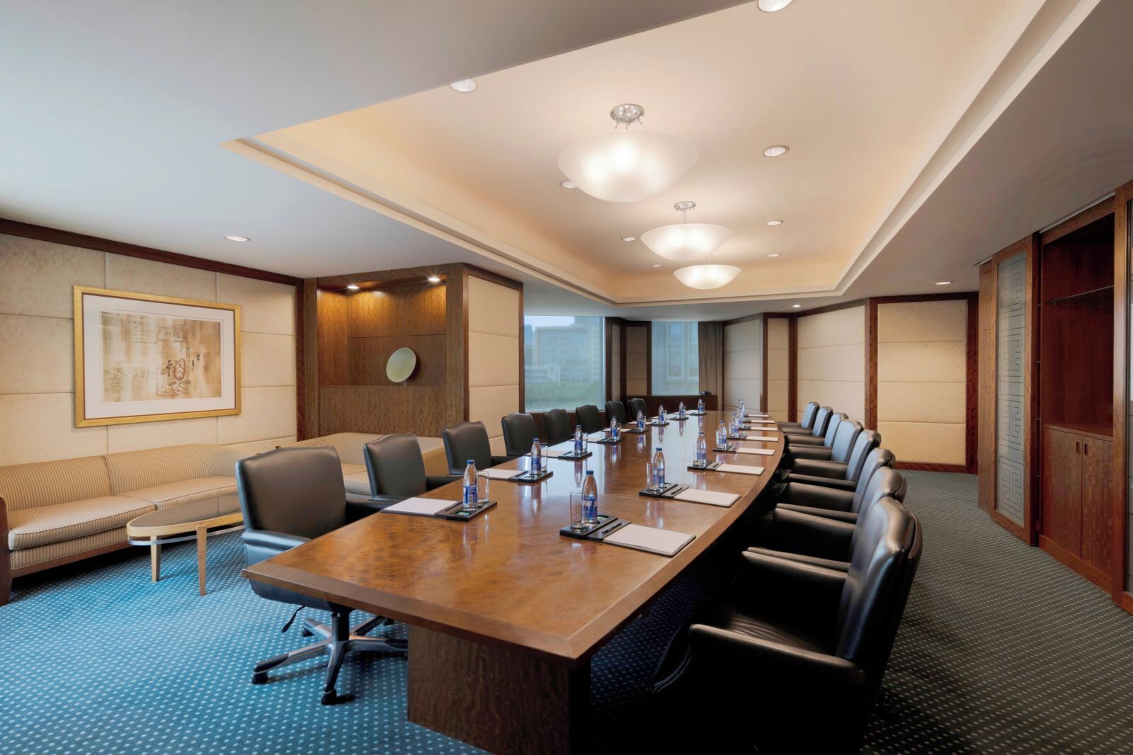 Un salón de conferencias con una mesa larga, sillas y un sofá.