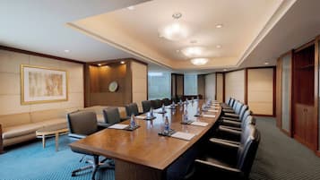 Un salón de conferencias con una mesa larga, sillas y un sofá.